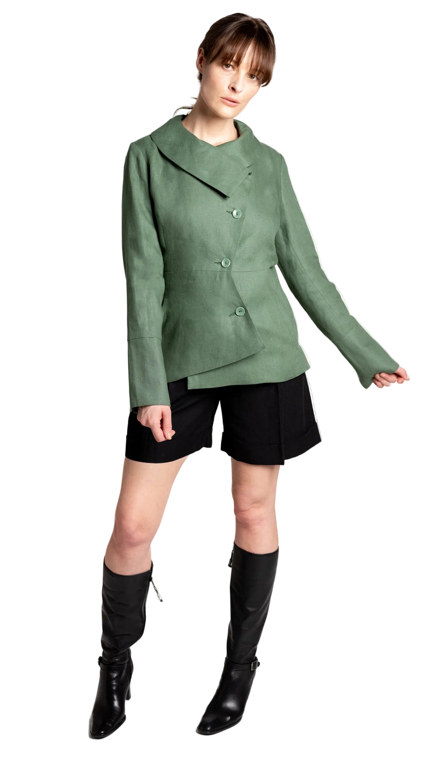 Person wearing a green linen blazer, black shorts, and black boots on a white background